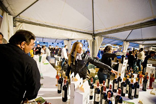 Florence, Italy - October 7, 2011: Outdoor Wine and Food Fair "Emozioni dal Chianti", Florence, Italy. Regular Food and Wine Festival taking place in Florence, demonstrating wines and food from few municipalities of Toscana. Shot made at the evening at Piazza Repubblica. People visiting event to taste and buy food and wine.